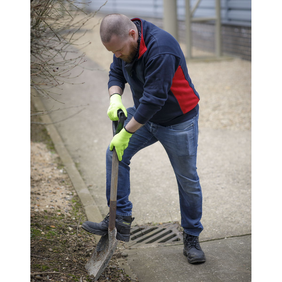 Person using a shovel on a sidewalk