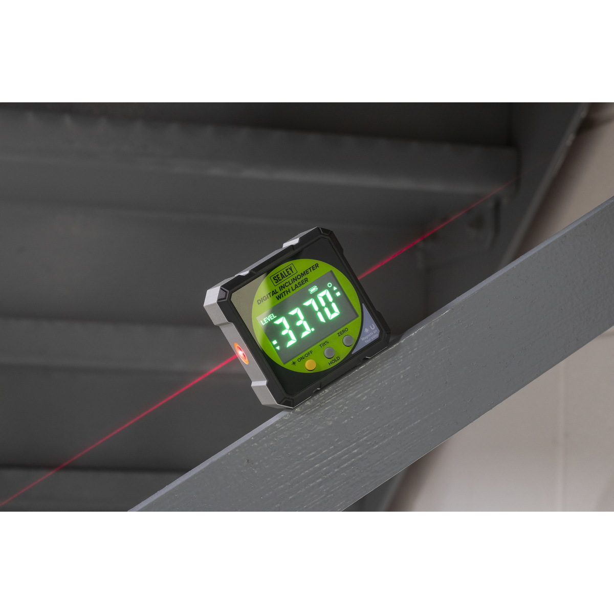 Digital laser level with red laser beam on a surface